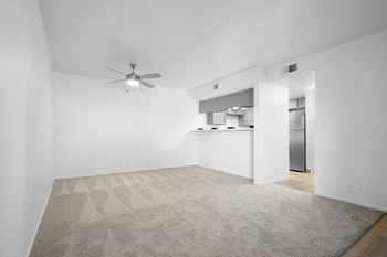 A room with a ceiling fan and a carpeted floor.